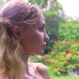 Model is wearing Flower headband paired with Origin Stud earring in rose-gold tined blush silver