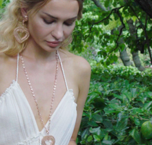 Model is wearing Heart Long chain necklace paired with Heart Medallion in rose-gold toned blush silver