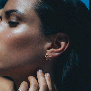 Model is wearing botanical stud earrings in rose gold